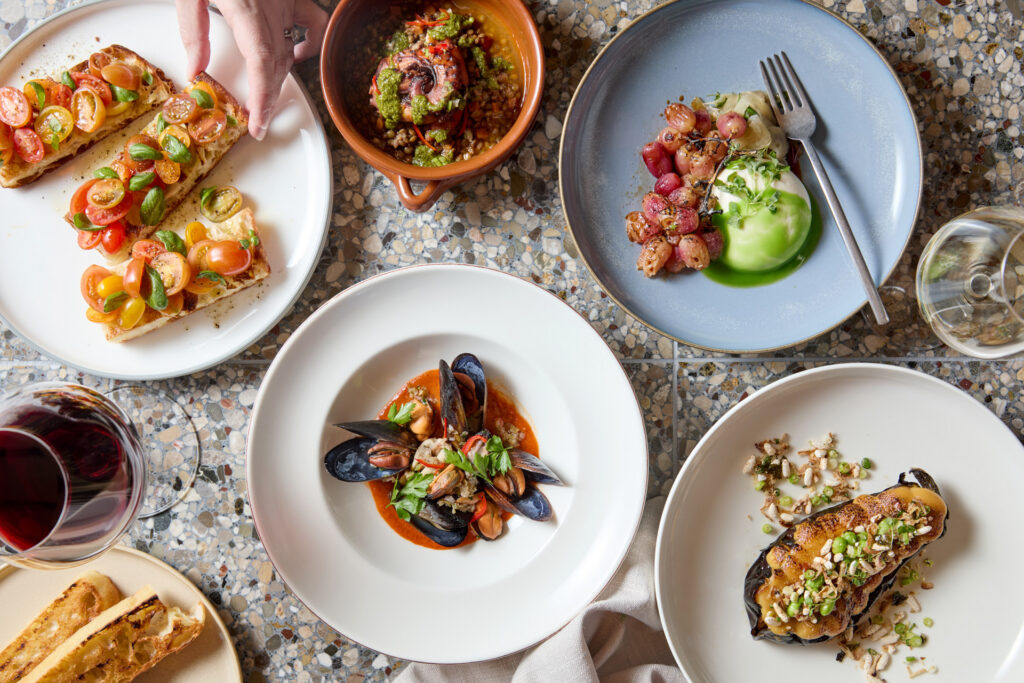Selection of Italian dishes served at Dodici, including pasta, seafood, fresh salads and shared plates arranged on a dining table
